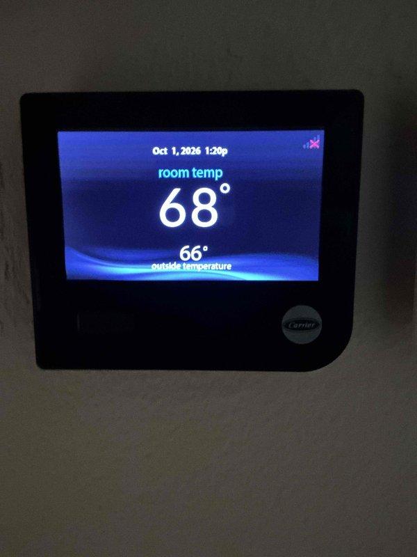 Completed prepaid heating maintenance visit on Carrier system. Verified thermostat operation displaying 68° room temperature with proper communication to equipment. Inspected and documented bent copper refrigerant line requiring attention during service call.