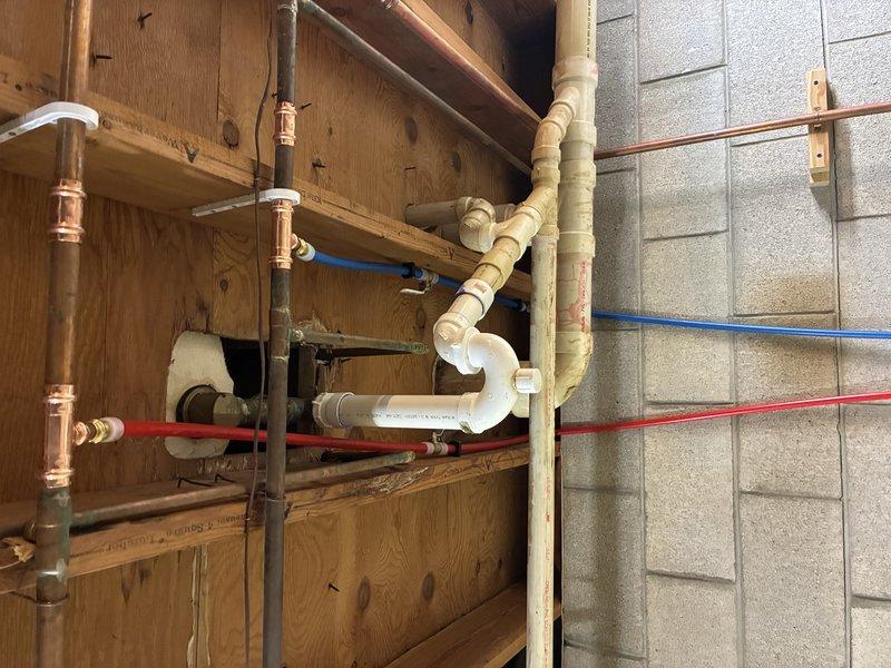 Completed installation of new tub trim and utility tub in basement area. Plumbing connections were established using copper supply lines, PEX water distribution tubing, and PVC drainage components including P-trap configuration. All fixtures were properly mounted, supply valves installed with brass fittings, and connections tested for leaks to ensure proper operation.