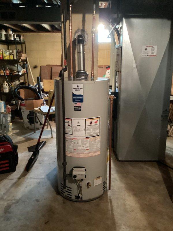 Completed installation of residential water heater in basement utility area. Unit positioned centrally with proper clearances from adjacent HVAC equipment and storage areas. Connected copper supply and discharge piping with appropriate valves and fittings per manufacturer specifications. Installed metallic exhaust vent pipe extending through ceiling joists to ensure proper venting of combustion gases. Verified all connections for leaks, confirmed proper operation of temperature and pressure relief valve, and tested unit functionality. Installation meets local building codes and manufacturer requirements for safe operation in residential basement setting.