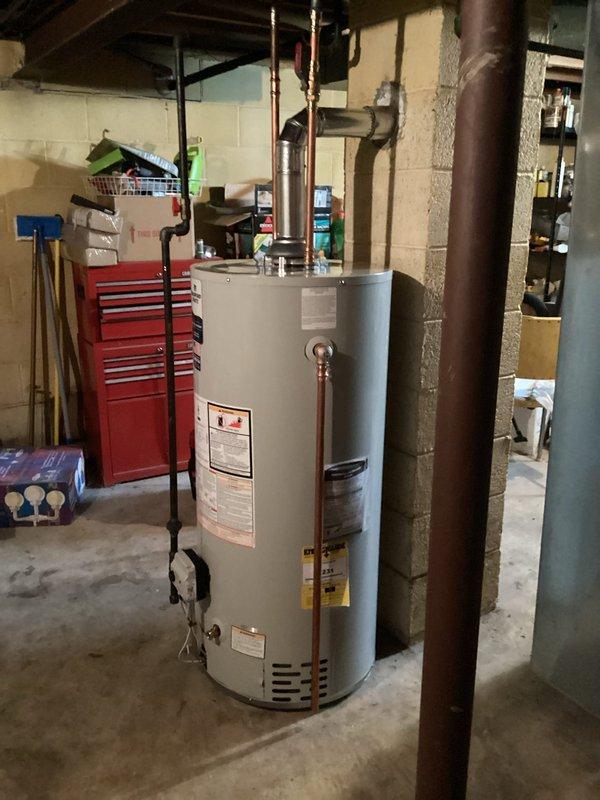 Completed installation of residential water heater in basement utility area. Unit positioned centrally with proper clearances from adjacent HVAC equipment and storage areas. Connected copper supply and discharge piping with appropriate valves and fittings per manufacturer specifications. Installed metallic exhaust vent pipe extending through ceiling joists to ensure proper venting of combustion gases. Verified all connections for leaks, confirmed proper operation of temperature and pressure relief valve, and tested unit functionality. Installation meets local building codes and manufacturer requirements for safe operation in residential basement setting.