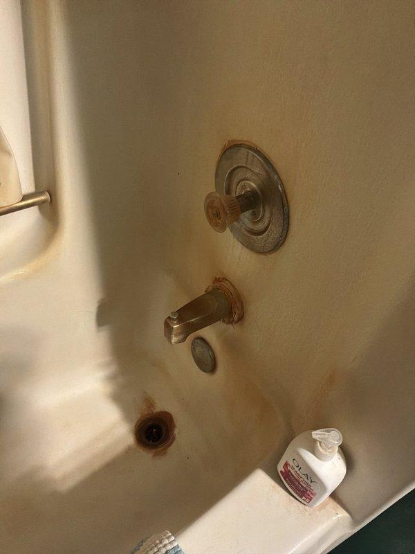 Conducted on-site plumbing estimate for bathroom tub/shower fixture replacement and kitchen faucet installation. Assessed existing chrome tub spout and shower control valve showing significant rust staining and mineral deposit buildup at wall penetrations, indicating potential water intrusion and need for fixture replacement. Reviewed new kitchen faucet assembly with pull-down spray hose, supply lines, and counterweight system for installation estimate.