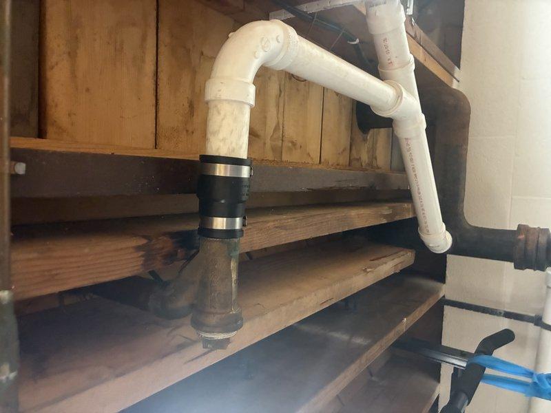 Completed tear out of existing plumbing piping beneath staircase and installed new PVC drain lines with proper fittings and connections in preparation for tile installation. Work included routing pipes through floor joists, securing all connections with appropriate couplings and clamps, and installing floor drain assembly to coordinate with customer's upcoming tile work.