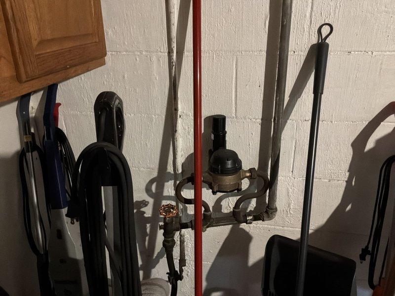 Conducted comprehensive estimate for replacement of 30+ year old residential water heater. Assessed existing plumbing infrastructure including supply lines, pressure regulator, shut-off valves, and gas/water connections. Documented current installation configuration with photographic evidence showing vertical pipe routing, pressure regulation system with gauge, and mounting arrangement on concrete block wall. Provided information regarding available military discount options and scheduled early morning arrival window for future installation work.