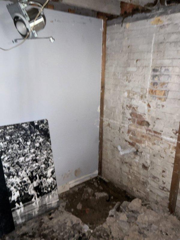 Conducted comprehensive plumbing assessment for sump pump installation in basement area showing significant moisture damage and water staining along walls and floor. Property currently enrolled in municipal pump program with no existing sump crock present. Evaluated unfinished basement space with exposed brick walls, concrete flooring, and visible water damage indicators including dark staining at base of walls and floor discoloration. Prepared complete estimate covering installation of new sump crock and pump system to address drainage concerns and prevent further water intrusion in lower level.