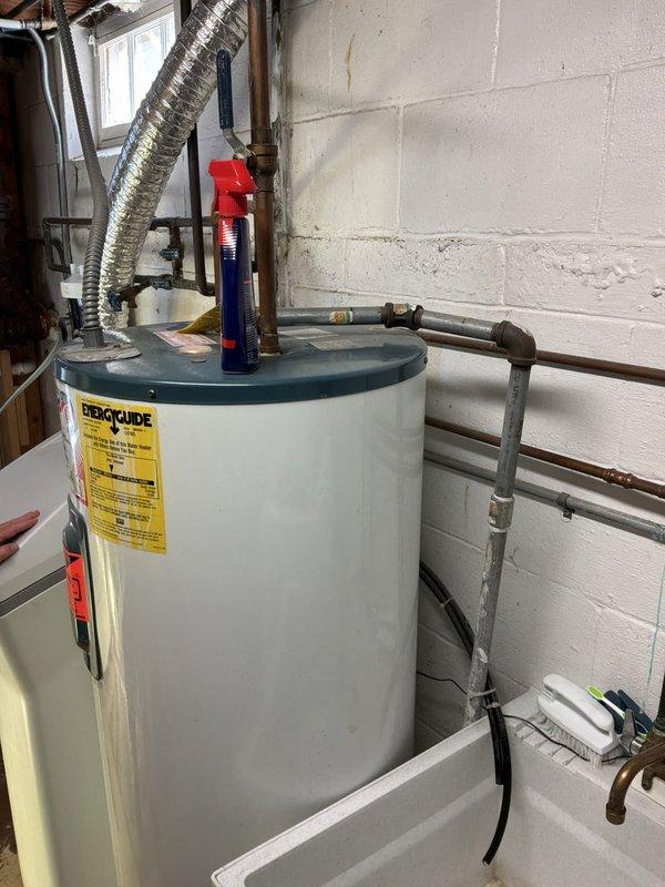 Completed water heater replacement estimate for 25-year-old conventional tank unit currently in operation. Customer declined tankless option and preferred standard tank water heater replacement. Assessed existing installation including copper supply lines, pressure relief valve, venting configuration, and electrical connections to determine replacement specifications and requirements.