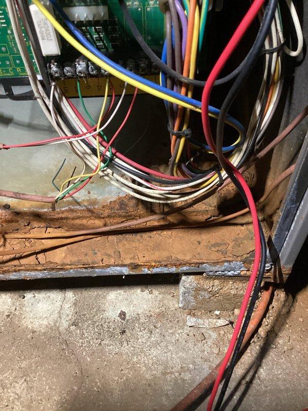 # HVAC No Heat Service Call

Responded to no heat complaint on residential HVAC system. Upon arrival, performed diagnostic inspection of furnace unit. Removed access panel to examine internal components and electrical systems. Visual inspection revealed significant corrosion and rust deterioration on metal framework and base platform, indicating prolonged moisture exposure. Multiple wire harnesses and circuit boards were examined for proper connections and functionality. Documented equipment condition through photographs showing corroded metal surfaces contrasting with operational electrical components. Blower motor assembly and control boards were inspected. System evaluated for safety concerns related to deteriorated metal components and potential impact on electrical systems. Equipment shows signs of extended service life despite being under ten years old, with environmental factors contributing to accelerated deterioration of metal components.