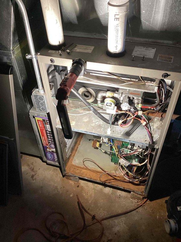 # HVAC No Heat Service Call

Responded to no heat complaint on residential HVAC system. Upon arrival, performed diagnostic inspection of furnace unit. Removed access panel to examine internal components and electrical systems. Visual inspection revealed significant corrosion and rust deterioration on metal framework and base platform, indicating prolonged moisture exposure. Multiple wire harnesses and circuit boards were examined for proper connections and functionality. Documented equipment condition through photographs showing corroded metal surfaces contrasting with operational electrical components. Blower motor assembly and control boards were inspected. System evaluated for safety concerns related to deteriorated metal components and potential impact on electrical systems. Equipment shows signs of extended service life despite being under ten years old, with environmental factors contributing to accelerated deterioration of metal components.