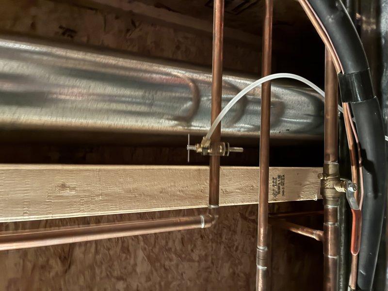 Completed comprehensive membership plumbing inspection of residential property during scheduled morning visit. Documented plumbing system conditions including copper pipe connections, wall penetrations, and mechanical space installations. Inspection revealed minor corrosion and discoloration at pipe connection points with visible rust marks on metal fittings, along with exposed plumbing components in attic/crawl space area featuring copper piping, HVAC ductwork, and various brass fittings in satisfactory working condition.