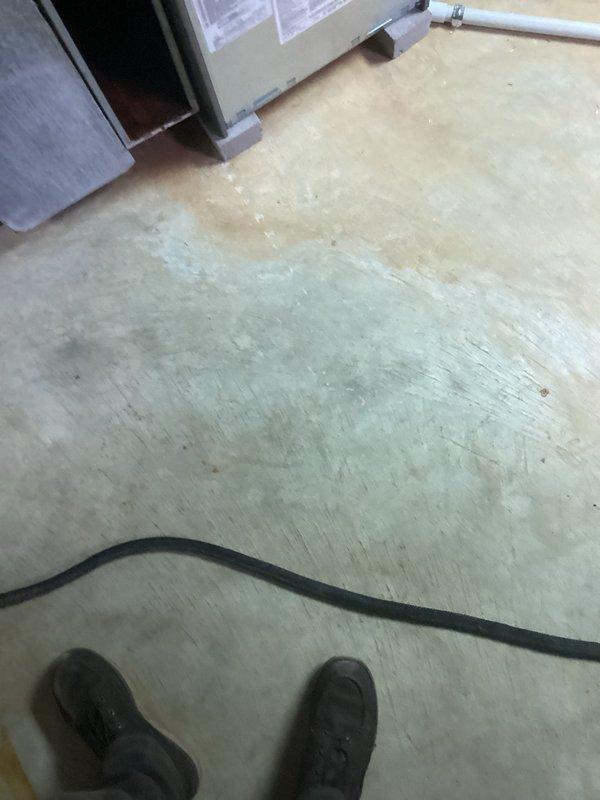 Responded to install callback for plenum air leakage that resulted in partial inspection failure. Upon arrival, inspected HVAC system and identified issue with air handler cabinet and plenum connections. Documented existing conditions including water damage on basement floor near equipment location. Removed access panel to assess internal components and ductwork connections, verified system configuration with condensate lines and circulation pump installation. Photographed equipment for quality assurance records and inspection documentation.