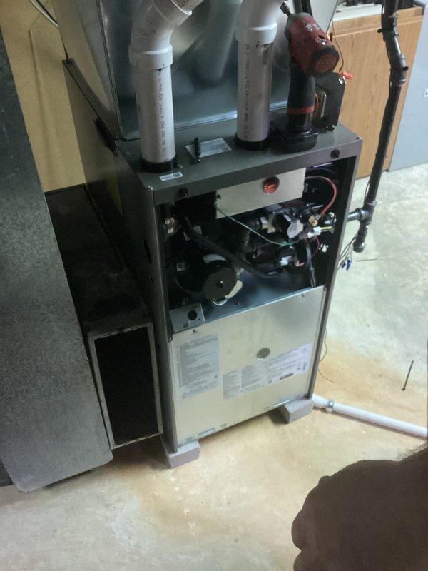 Responded to install callback for plenum air leakage that resulted in partial inspection failure. Upon arrival, inspected HVAC system and identified issue with air handler cabinet and plenum connections. Documented existing conditions including water damage on basement floor near equipment location. Removed access panel to assess internal components and ductwork connections, verified system configuration with condensate lines and circulation pump installation. Photographed equipment for quality assurance records and inspection documentation.