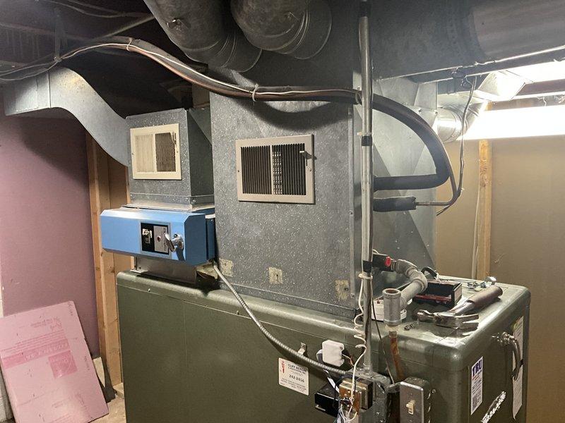 Conducted on-site assessment of existing oil-fired furnace system in basement mechanical room to provide estimate for conversion to gas-fired heating system. Evaluated current ductwork configuration, including existing metal supply and return plenums, and documented equipment layout and available space for new gas furnace installation. Confirmed gas line is already run to the location, simplifying the conversion process. Photographed existing HVAC equipment, ductwork connections, and mechanical room layout to prepare accurate replacement estimate and verify compatibility with new gas furnace specifications.