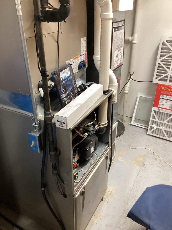 Responded to service call for water accumulation beneath furnace unit. Upon inspection, diagnosed failed furnace gasket as source of water leak. Replaced defective gasket with OEM Carrier replacement part #338806-401 to restore proper seal and eliminate water leakage. Verified repair, confirmed no active leaks, and returned unit to normal operation.