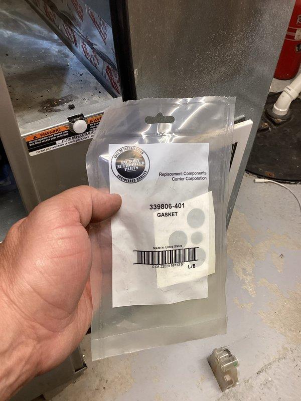 Responded to service call for water accumulation beneath furnace unit. Upon inspection, diagnosed failed furnace gasket as source of water leak. Replaced defective gasket with OEM Carrier replacement part #338806-401 to restore proper seal and eliminate water leakage. Verified repair, confirmed no active leaks, and returned unit to normal operation.