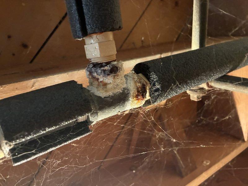Diagnosed and identified a leaking temperature and pressure relief valve on a Rheem 40-gallon power vent water heater model PV12-2. Upon inspection, the T&P valve showed visible corrosion and deterioration at the copper pipe connection, with heavy oxidation present on the fitting. The valve was actively leaking, creating a potential safety hazard and water damage risk. Documented the condition of the unit and the corroded T&P valve assembly with photographic evidence showing the extent of the deterioration and the water heater's location in the utility space.