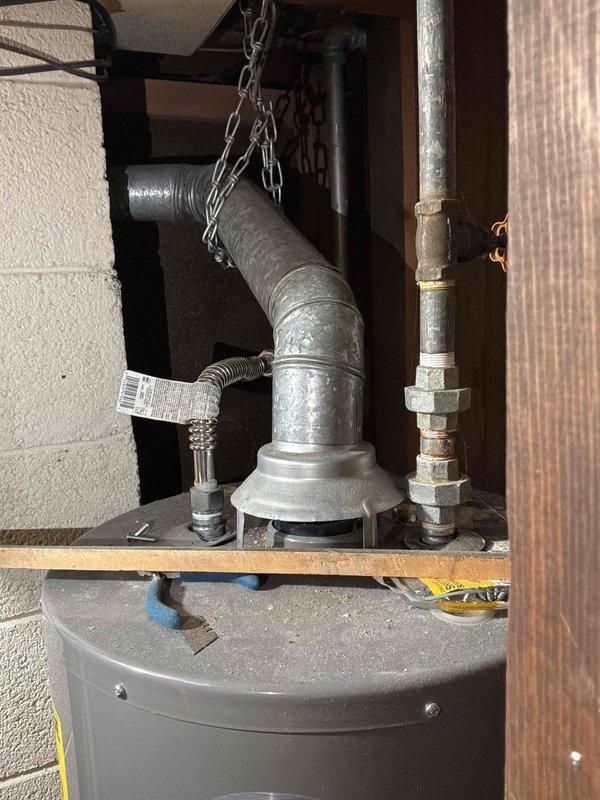 Completed furnace replacement estimate for natural gas unit located in basement. System assessment revealed aging equipment with deteriorated ductwork showing significant surface wear, peeling insulation, and exposed metal sections requiring attention. Documented existing mechanical installation including water heater, ventilation components, and associated plumbing connections for comprehensive replacement planning.