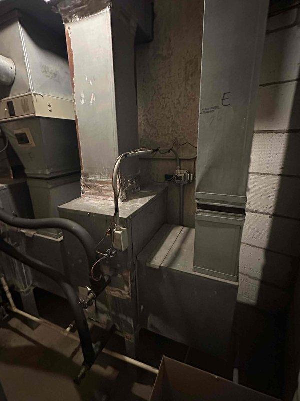 Conducted on-site assessment of existing air handler unit located in hallway maintenance closet for replacement estimate. Documented current HVAC system configuration including metal ductwork assembly, existing air handler cabinet, and associated mechanical connections in basement utility space. Photographed equipment specifications, installation location, and surrounding infrastructure to prepare comprehensive replacement estimate for customer review via email.