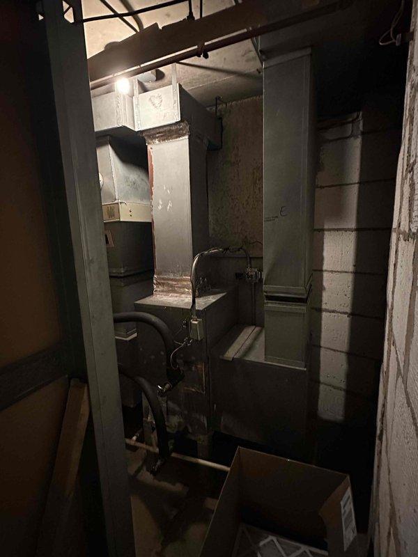 Conducted on-site assessment of existing air handler unit located in hallway maintenance closet for replacement estimate. Documented current HVAC system configuration including metal ductwork assembly, existing air handler cabinet, and associated mechanical connections in basement utility space. Photographed equipment specifications, installation location, and surrounding infrastructure to prepare comprehensive replacement estimate for customer review via email.