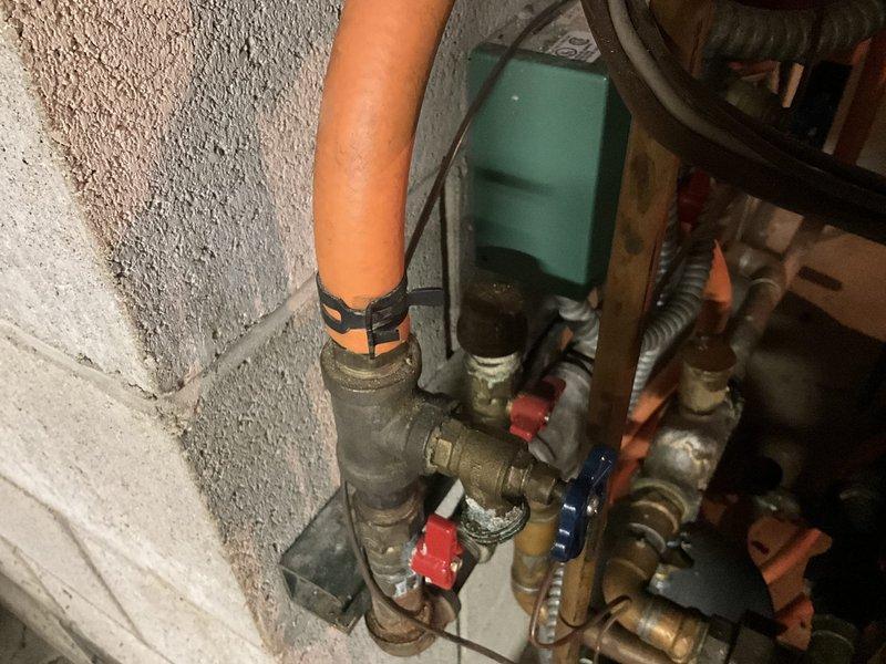 Responded to emergency call for leaking Burnham boiler water tank. Upon arrival, assessed the system and documented existing plumbing infrastructure, including aged brass valves, piping assembly, and compromised tank condition. Provided estimate for complete boiler replacement to resolve the active water leak and prevent further system failure.