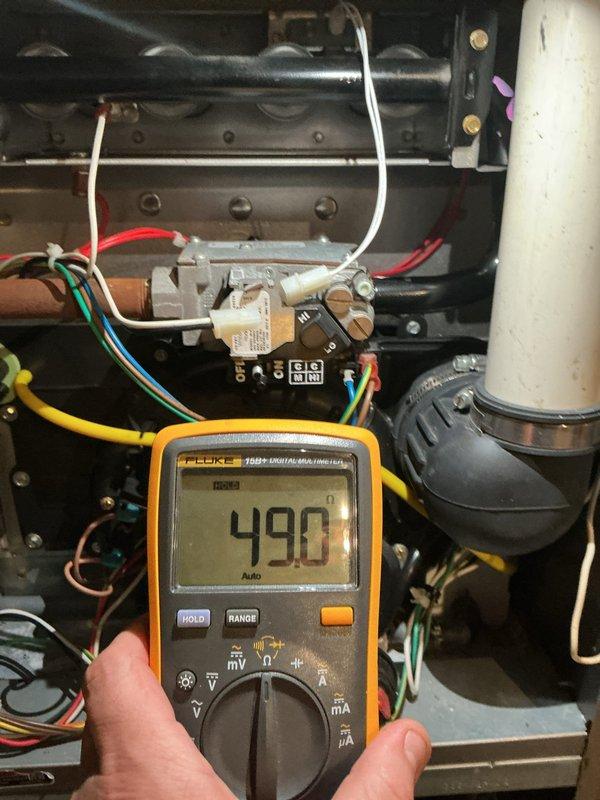 Responded to no-heat call on heating system over 10 years old with reported hole in unit and carbon monoxide concern. Upon arrival, performed comprehensive system diagnostics using digital multimeter to test electrical components and verify proper voltage readings throughout the control circuit. Measured voltage at burner assembly and control module, obtaining readings of 490-502 volts AC, indicating proper transformer output to gas valve and ignition system.

Conducted thorough visual inspection of heat exchanger and burner assembly for cracks, holes, or deterioration that could allow carbon monoxide leakage into living space. Examined all accessible sections of heat exchanger, flue pipe connections, and combustion chamber for structural integrity. Inspected flexible flue coupling and metal clamp connections for proper seal and secure attachment to white cylindrical vent pipe.

Tested all safety controls including limit switches, flame sensor, and pressure switches to ensure proper op