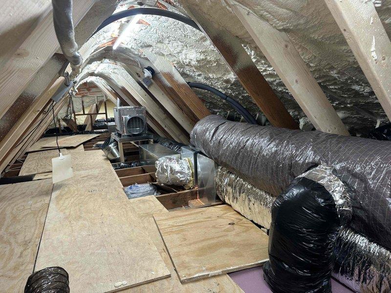 Completed ERV installation warranty inspection in residential attic space. Verified proper installation of energy recovery ventilator unit and associated ductwork system. Documented existing HVAC infrastructure including large-diameter flexible ducts with metallic insulation, spray foam wall insulation, and reflective foil-faced roof insulation. Confirmed all ductwork connections are secure, properly insulated, and sealed. Inspected electrical connections to junction box and conduit routing. Verified adequate clearances around equipment and ductwork per manufacturer specifications. System operational and performing within normal parameters.