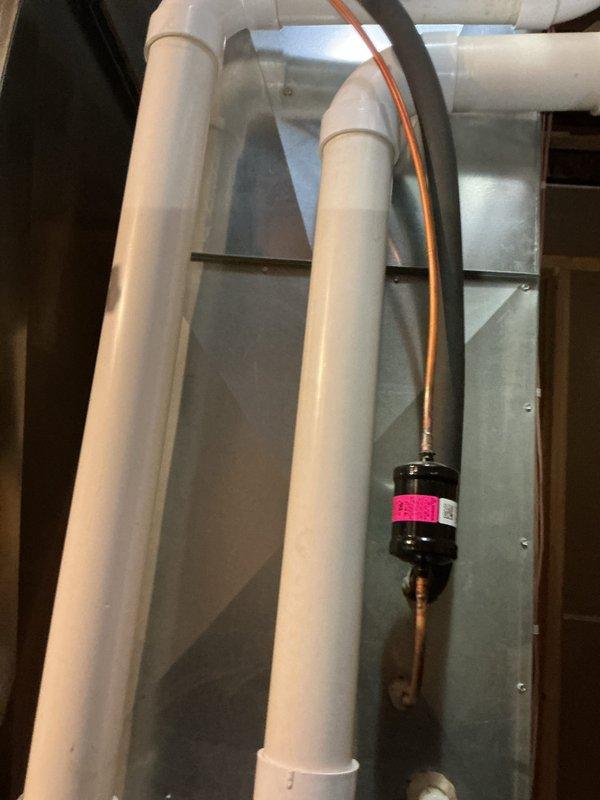 Performed prepaid maintenance visit on residential HVAC system. Cleared and blew out condensate drain line for air conditioning unit, noting rust present in drain assembly. Opened furnace access panel to inspect internal components including blower motor, gas valve assembly, and electrical connections. Verified proper operation of heating system as part of recurring membership maintenance service.