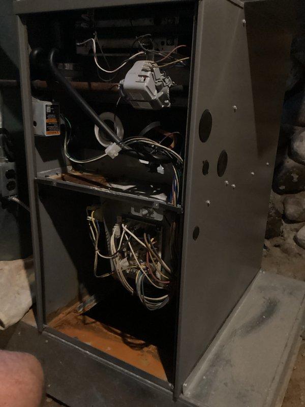 Responded to a no-heat call on a 15-year-old Lennox gas furnace where the thermostat and furnace would click upon call for heat, but the blower motor failed to operate. Diagnosed faulty blower motor or control board issue by inspecting internal components with access panel removed. Documented furnace interior showing blower assembly, control board, wiring harnesses, and electrical connections for further repair recommendations.