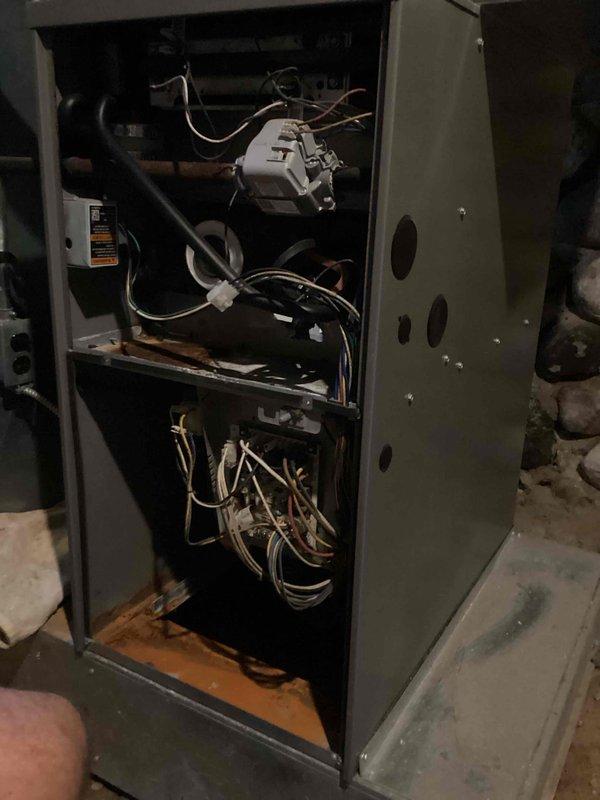 Responded to a no-heat call on a 15-year-old Lennox gas furnace where the thermostat and furnace would click upon call for heat, but the blower motor failed to operate. Diagnosed faulty blower motor or control board issue by inspecting internal components with access panel removed. Documented furnace interior showing blower assembly, control board, wiring harnesses, and electrical connections for further repair recommendations.