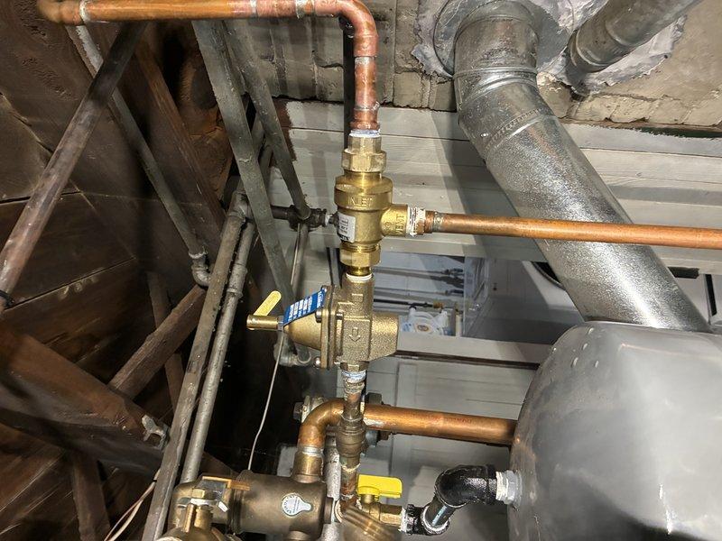 Replaced the boiler auto fill valve backflow preventer on the copper piping assembly. The new backflow device was installed with brass fittings to maintain proper water pressure regulation and prevent contamination of the potable water supply. System was tested and verified to be operating correctly with no leaks detected.