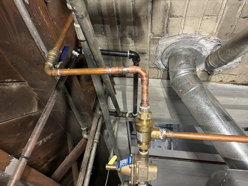Replaced the boiler auto fill valve backflow preventer on the copper piping assembly. The new backflow device was installed with brass fittings to maintain proper water pressure regulation and prevent contamination of the potable water supply. System was tested and verified to be operating correctly with no leaks detected.