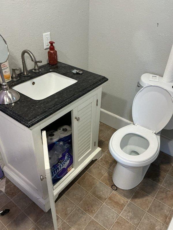 Responded to service call for non-flushing toilet and general plumbing assessment. Inspected bathroom fixtures including toilet and vanity plumbing connections, as well as basement utility area containing main plumbing lines, PVC drainage system, and associated infrastructure mounted along stone foundation wall. Diagnosed toilet flushing mechanism failure and evaluated condition of visible supply lines, drain pipes, and aged plumbing components throughout accessible areas. Documented existing plumbing configuration with photographic evidence for repair recommendations and potential replacement considerations.