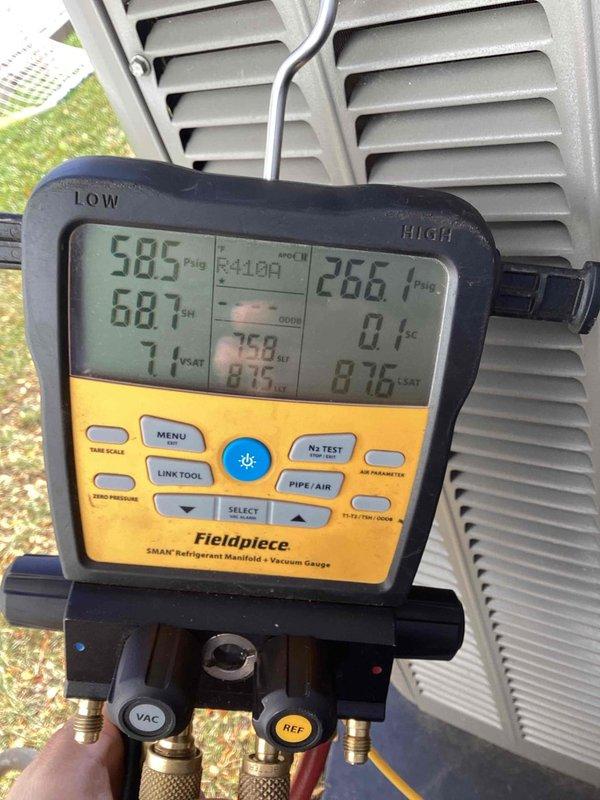Responded to no cooling callback on residential HVAC system. Upon arrival, connected manifold gauges to outdoor condensing unit and performed system diagnostics. Pressure readings indicated abnormally high head pressure on the high side (687 psig) and elevated suction pressure on the low side (585 psig), with superheat reading of 71°F suggesting potential airflow restriction or system overcharge. Removed top access panel to inspect condenser fan operation and internal components. Based on gauge readings and visual inspection, identified issue preventing proper cooling operation and addressed accordingly to restore system functionality.