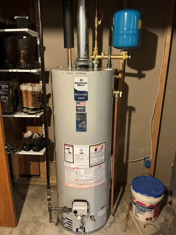 Responded to service call for leaking 40-gallon natural gas Bradford White water heater. Upon arrival, confirmed severe tank leak requiring full unit replacement. Removed existing failed water heater and installed new 40-gallon natural gas tall model with proper venting, gas line connections, and plumbing tie-ins. Connected copper supply lines, installed safety relief valve, and mounted expansion tank. Verified all connections for proper operation and tested unit for leaks before restoring service.