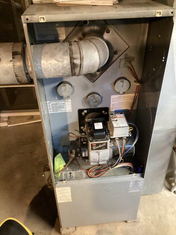 Inspected the oil-fired furnace equipped with a Beckett burner assembly to verify the completeness of the prior seasonal tune-up and confirm safe operation. Visually evaluated the burner, control wiring, flue connection, and cabinet interior, finding no signs of frost, ice, or significant rust. The unit was found in serviceable condition and ready for heating use.