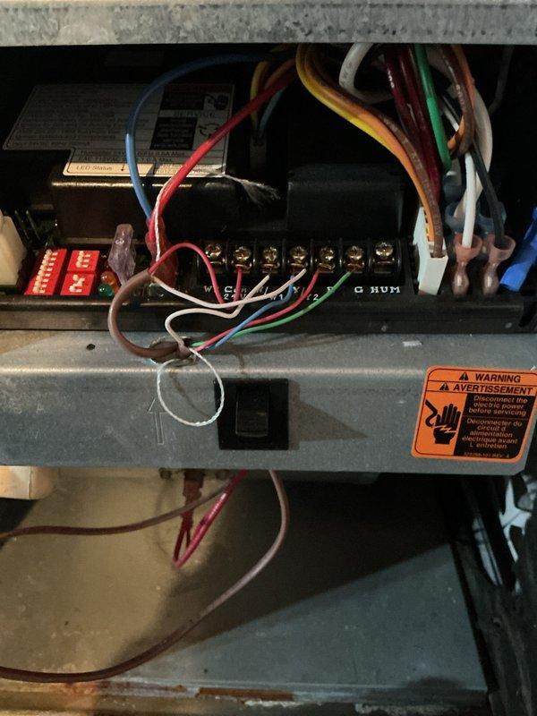 Performed a seasonal furnace tune-up, accessing the burner compartment and control cabinet to inspect the burner assembly, control board, transformer, relays, and low-voltage thermostat terminal connections (W, C, Y, G, HUM) for secure termination and proper wire routing. Verified wiring harness integrity and cleaned accumulated dust and debris from the cabinet interior, then reinstalled the access panel and confirmed the unit was ready for operation.