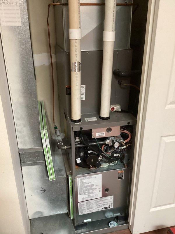 Performed a complete furnace tune-up on a gas-fired unit installed in a utility closet, including removal of the lower front panel to inspect the gas valve assembly, inducer/blower motor, burner compartment, control board, and wiring connections. Verified the PVC venting, gas supply line and fittings, condensate drain components, and transition ductwork were secure and sealed, with no signs of rust, frost, or visible damage. Unit was reassembled and left in proper working condition.
