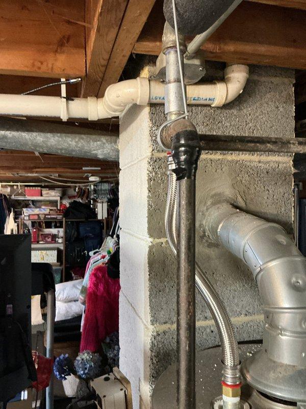 Diagnosed a no-hot-water complaint on a gas-fired tank water heater where the pilot would light briefly but fail to stay lit, inspecting the unit, gas supply piping, flexible connectors, and galvanized vent connection with no visible leaks, corrosion, or venting obstructions. Performed repair to restore reliable pilot and burner operation, then relit the appliance and verified sustained flame and proper draft. System is operating normally and producing hot water.