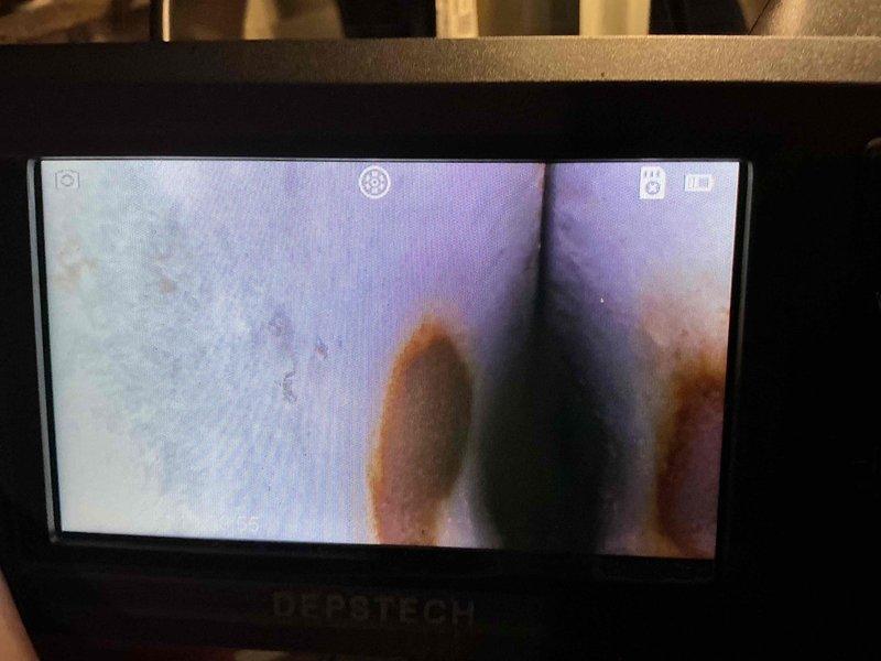 Performed a full HVAC tune-up, measuring supply air temperature at the register (112.6°F) to verify heating output and noting dirt and debris buildup on the register slats. Used a borescope to inspect the heat exchanger and found corrosion and rust patches along an internal seam, which should be monitored and evaluated for further repair or replacement.