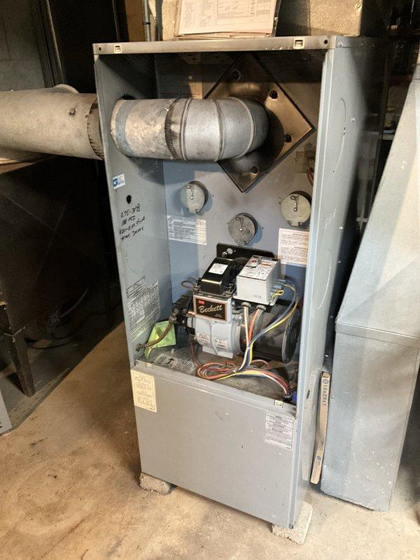Performed an on-site estimate for replacement of the existing Bryant oil-fired furnace (Beckett burner) with a new oil furnace, inspecting the unit, flue connection, and ductwork, which showed dust and soot accumulation and discoloration. Also evaluated conversion options from oil to LP, since no natural gas service is available at the property, and documented equipment conditions with photos for the replacement proposal.