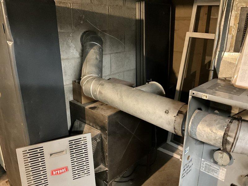 Performed an on-site estimate for replacement of the existing Bryant oil-fired furnace (Beckett burner) with a new oil furnace, inspecting the unit, flue connection, and ductwork, which showed dust and soot accumulation and discoloration. Also evaluated conversion options from oil to LP, since no natural gas service is available at the property, and documented equipment conditions with photos for the replacement proposal.
