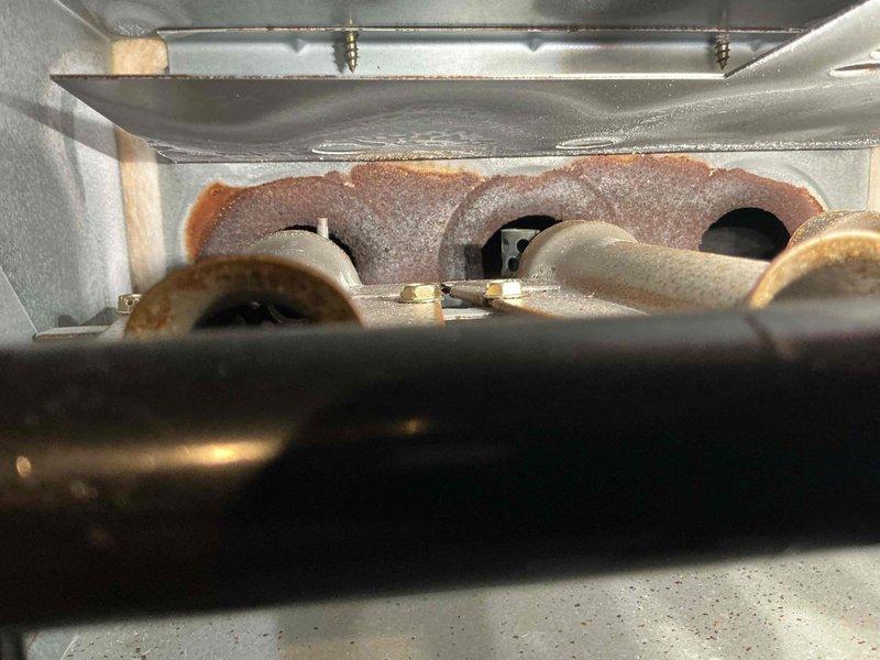 Performed tune-ups on two basement gas furnaces, including inspection of burner assemblies and electrical measurements with a clamp meter on the blower motor circuit. Significant corrosion was found at the heat exchanger inlet openings on one unit, along with oxidation on the burner tubes, and further evaluation of the heat exchanger's condition is recommended.