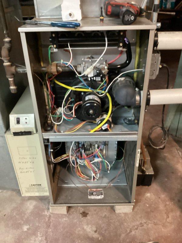 Performed tune-ups on two gas furnaces, one in the residence and one in the garage, including removal of access panels to inspect the gas valve assembly, inducer motor, blower components, control board, and wiring harness. Verified equipment data plates and recorded model and serial information for service records. No frost, rust, or component breakage was observed, and both units were reassembled and returned to service.