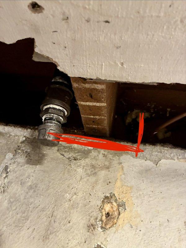 Assessed the site for a new gas line to the kitchen range and inspected the existing black iron piping, finding a capped threaded termination within the wall cavity adjacent to the concrete wall. Documented the cap, fittings, and joint condition (including mineral residue at the threads) and marked the pipe routing for the proposed extension, pending verification of capacity and code-compliant installation.