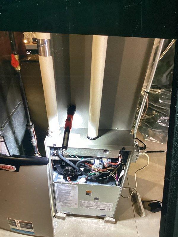 Performed a no-charge second-opinion evaluation of the air conditioning system, previously reported by another contractor as improperly installed, inspecting the Lennox gas furnace with the access panel removed to review the burner compartment, blower assembly, wiring, gas line and shutoff, and PVC venting. Observed light granular debris on the burner area surface but found no frost, rust, or visible damage, and the furnace was documented with photos for the customer's records.