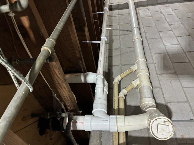 Installed a new toilet flange and bathtub drain, including PVC drain and vent piping routed through the framing with proper support. Pipe runs were connected with couplings, tee fittings, and sweeping elbows, and secured with hanger straps to the framing. A cleanout with a threaded plug was provided for future access, and all connections were completed and inspected for proper fit and alignment.