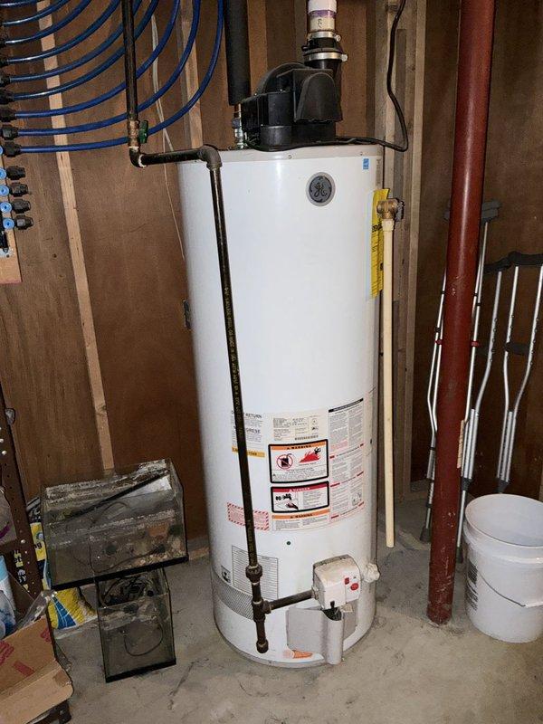 Performed an on-site estimate for replacement of a gas power-vent water heater, assessing the existing tank, PVC exhaust venting, gas supply piping, and surrounding supply plumbing for code-compliant removal and installation. Also evaluated the sump pump system for replacement with a battery backup unit, documenting existing conditions and noting that clutter and stored materials in the work areas will need to be cleared for safe access.