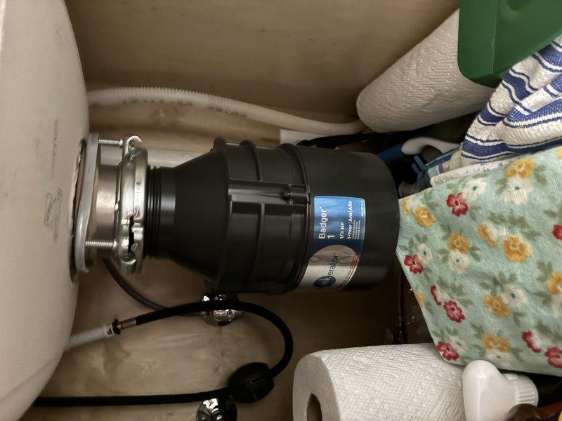 Serviced an InSinkErator Badger 1 (1/3 HP) garbage disposal that was jammed by a foreign object lodged in the grinding chamber. Inspected the unit and under-sink connections, cleared the obstruction, and freed the impeller assembly to restore normal rotation. Verified proper operation and drainage with no leaks at the mounting assembly or discharge connections.