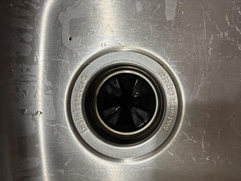 Serviced an InSinkErator Badger 1 (1/3 HP) garbage disposal that was jammed by a foreign object lodged in the grinding chamber. Inspected the unit and under-sink connections, cleared the obstruction, and freed the impeller assembly to restore normal rotation. Verified proper operation and drainage with no leaks at the mounting assembly or discharge connections.