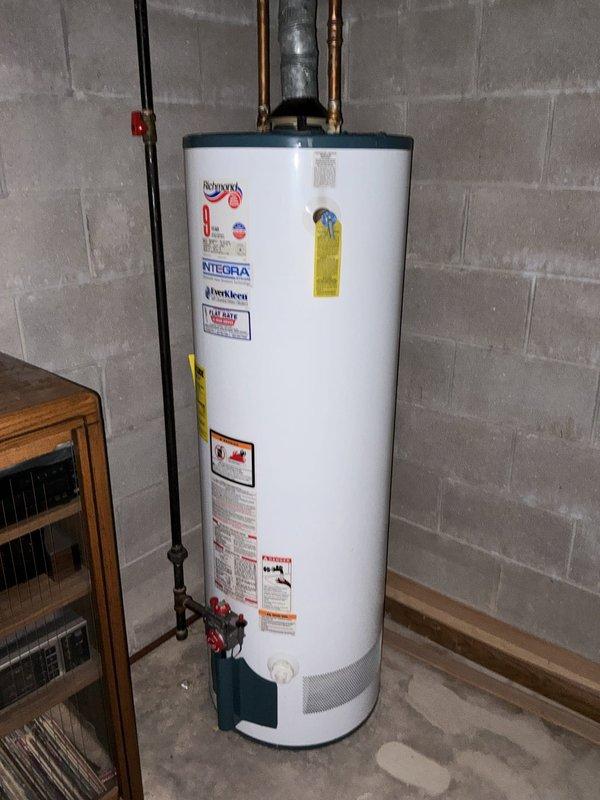 Performed an on-site estimate for replacement of an approximately 22-year-old 40-gallon water heater. Inspected the existing atmospheric-vent gas unit, noting the draft hood and galvanized flue connection, copper water supply lines with shutoff valve, and gas supply with shutoff, and found no visible leaks, corrosion, or damage. Documented the installation with photos to support replacement recommendations based on the unit's age.