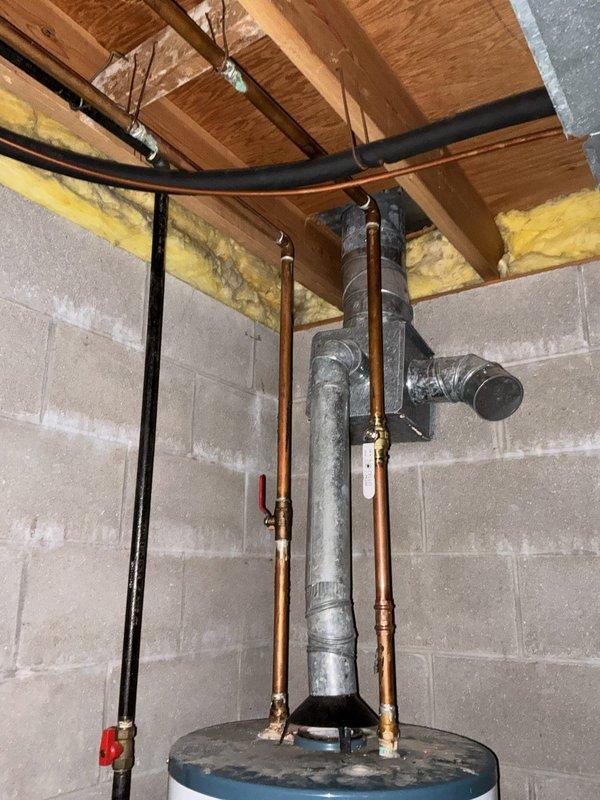 Performed an on-site estimate for replacement of an approximately 22-year-old 40-gallon water heater. Inspected the existing atmospheric-vent gas unit, noting the draft hood and galvanized flue connection, copper water supply lines with shutoff valve, and gas supply with shutoff, and found no visible leaks, corrosion, or damage. Documented the installation with photos to support replacement recommendations based on the unit's age.