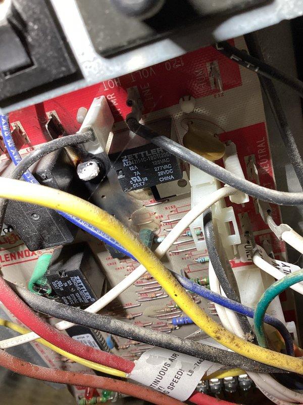 Responded to a no-heat call on a 10+ year old Lennox gas furnace with red and green diagnostic LEDs flashing. Inspection found the integrated furnace control board heavily scorched and burned around the relay and capacitor area, with dust and grime buildup throughout the control compartment. Significant corrosion was also present in the cabinet base pan, with rust staining running onto the floor, indicating prior moisture or condensate leakage; the board failure and corrosion were documented with photos for the customer's review and further recommendations.